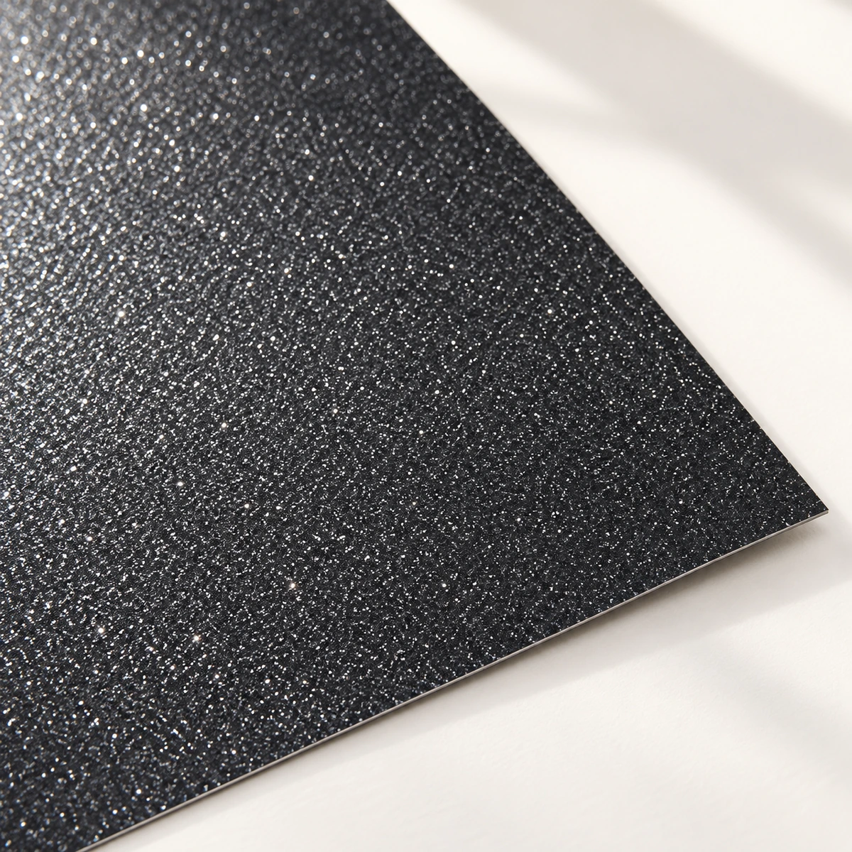 Detalle del acabado escarchado de cartulina glitter negra de 220 g